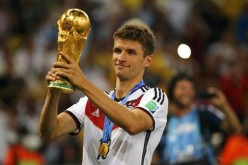 Bayern Munich and Germany national team's Thomas Müller lifting the 2014 World Cup.