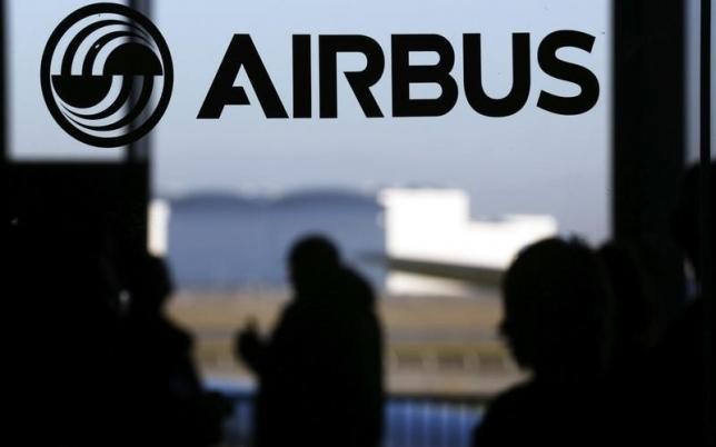 People are silhouetted past a logo of the Airbus Group during the Airbus annual news conference in Colomiers, near Toulouse, on Jan. 13, 2015.