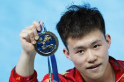 China's rookie diver Xie Siyi shows his medal after winning the men's 1m springboard final at the FINA World Swimming Championships on Monday, July 27, at Kazan, Russia.