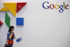 A woman walks past a logo of Google at the Global Mobile Internet Conference (GMIC) 2015 in Beijing, China, April 28, 2015.