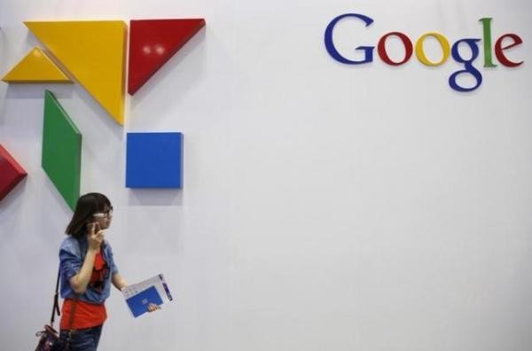 A woman walks past a logo of Google at the Global Mobile Internet Conference (GMIC) 2015 in Beijing, China, April 28, 2015.