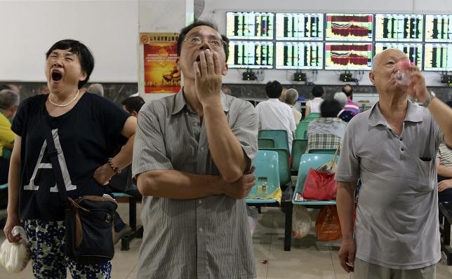 Investors stare at computer screens displaying stock information at a brokerage house in Wuhan, Hubei Province, China, July 3, 2015.