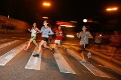 Runners take the path along the riverbank in Xuhui District in a weekly night event.