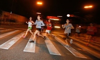 Runners take the path along the riverbank in Xuhui District in a weekly night event.