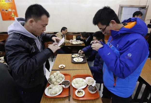 Diners take pictures of the steamed bun meal that President Xi Jinping ate and made famous at the Qingfeng restaurant in Beijing.