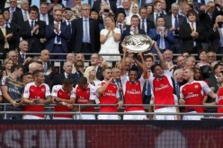 Arsenal's Francis Coquelin and Olivier Giroud lift the trophy after winning the FA Community Shield against rival Chelsea.