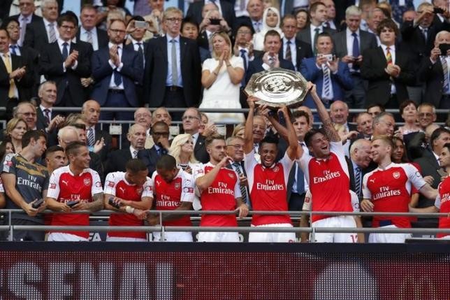 Arsenal's Francis Coquelin and Olivier Giroud lift the trophy after winning the FA Community Shield against rival Chelsea.