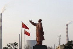 Smoke comes out of the chimneys of Wuhan Iron and Steel Corp. in Wuhan, Hubei Province, where a statue of Mao Zedong stands.