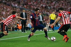 Barcelona's Lionel Messi (middle) works on two Athletic Bilbao defenders.