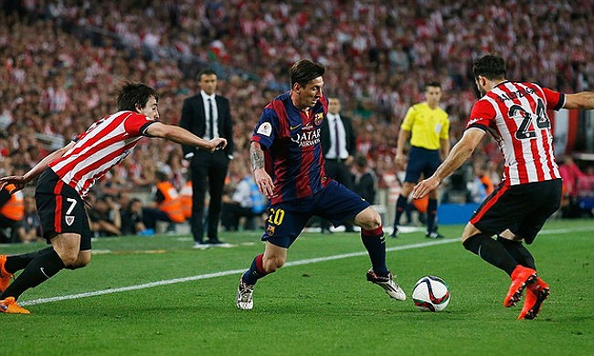 Barcelona's Lionel Messi (middle) works on two Athletic Bilbao defenders.