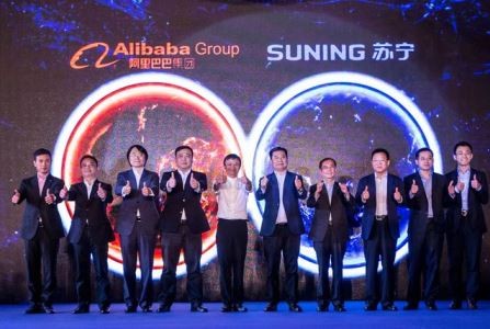 Alibaba's founder Jack Ma and Suning chairman Zhang Jindong, with officials from both companies, pose for a photo at the announcement of the two companies' cooperation in Nanning, Aug. 10.