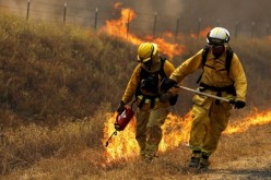 A Cal Fire firefighter sets a backfire with a driptorch along Highway 20 during the Rocky Fire near Lower Lake, California August 3, 2015.