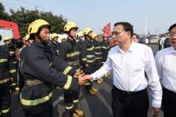 A firefighter shakes hands with Premier Li Keqiang during the Chinese leader's visit in Tianjin on Sunday, Aug. 16.