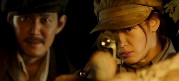 Jun Ji-hyun aims at a target while Lee Jung-jae observes in the background in the film "Assassination."
