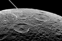 A view of Saturn's moon Dione captured by NASA's Cassini spacecraft during a close flyby on June 16, 2015. The diagonal line near upper left is the rings of Saturn, in the distance.