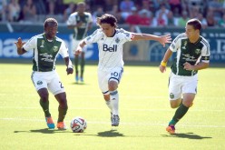 Portland Timbers midfielders Diego Chara and Will Johnson try to steal the ball away from Vancouver midfielder Mauro Rosales.