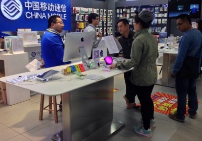 Customers look at Apple iPhones at a mobile store in China.
