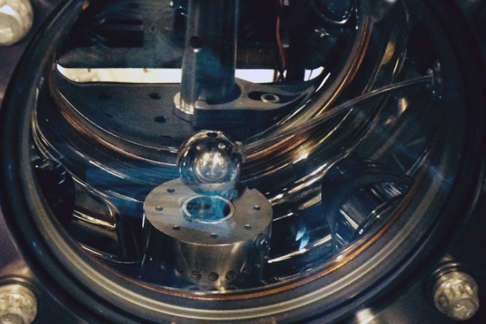 The vacuum chamber of the atom interferometer contains a one-inch diameter aluminum sphere. If chameleons exist, cesium atoms would fall toward the sphere with a slightly greater acceleration than their gravitational attraction would predict.