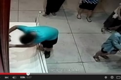 Still from a YouTube video of a Taiwanese boy who falls and punctures an oil canvas at an exhibition in Taiwan.