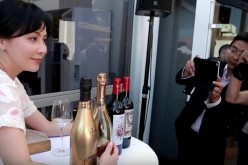 Carina Lau poses with her wines and champagnes in an event in France.