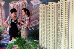 A prospective home buyer makes inquires about a new apartment project  at a real estate fair in Yichang, central China's Hubei Province.