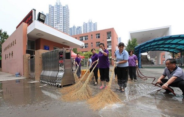 Personnel clean the school grounds prior to the opening of classes in Binhai in Tianjin.
