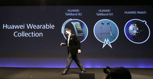 Huawei chief executive Richard Yu walks past his presentation on Huawei's wearable collection.