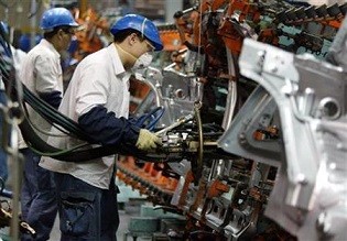 A worker checks car parts at a manufacturing plant in Shanghai. 