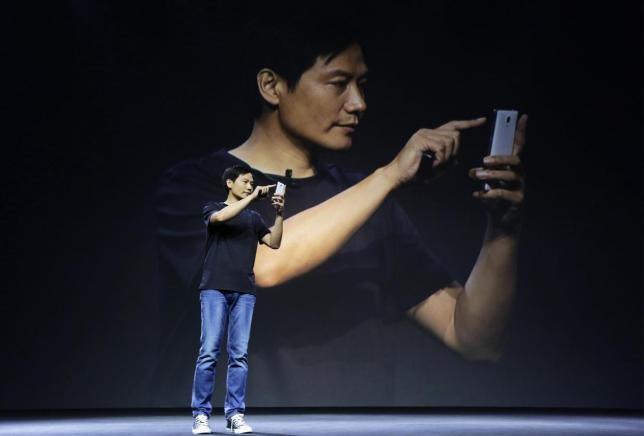 Lei Jun, founder and CEO of China's mobile company Xiaomi, shows the new features at a launch ceremony of Xiaomi Phone 4, in Beijing, July 22, 2014.