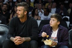 Soccer star David Beckham (L) and his son Brooklyn watch the Los Angeles Lakers play the Denver Nuggets during Game 1 of their first round NBA Western