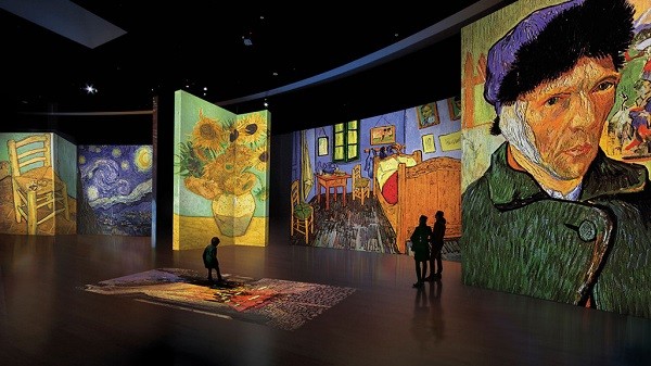 A child steps on an image while two other visitors study "The Bedroom" (1889) at the “Van Gogh Alive – The Experience,” which provides visitors a unique way of knowing the Dutch painter and his art.