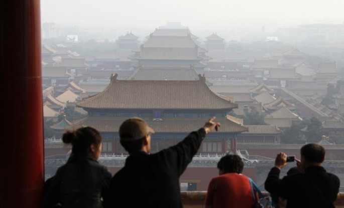 Tourists look over the Forbidden City from Jingshan Park in Beijing, Oct. 13, 2009. 