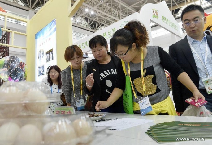 Women sample food at the China-Arab States Expo 2015 in Yinchuan.