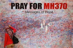 A woman leaves a messages of support and hope for the passengers of the missing Malaysia Airlines MH370 in central Kuala Lumpur March 16, 2014.