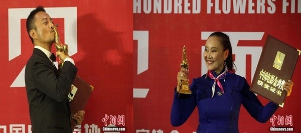 Zhang Hanyu and Ba Dema pose for pictures with their trophy during the 24th Golden Rooster and Hundred Flowers Film Festival in Jilin Province.