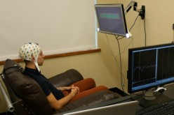 University of Washington graduate student Jose Ceballos wears an electroencephalography (EEG) cap that records brain activity and sends a response to a second participant over the Internet.