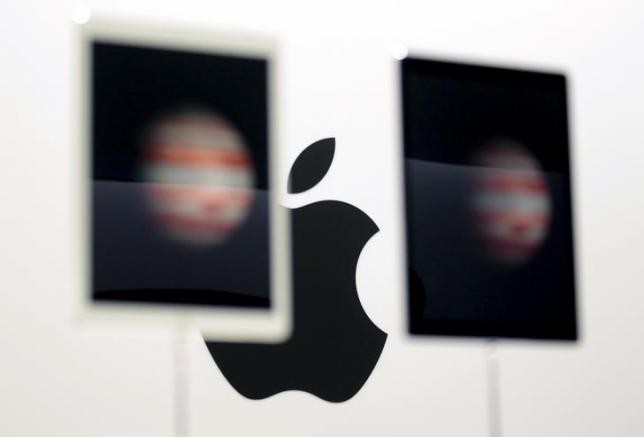The Apple logo is seen behind a pair of Apple iPad Pros on display in San Francisco, California, Sept. 9, 2015.