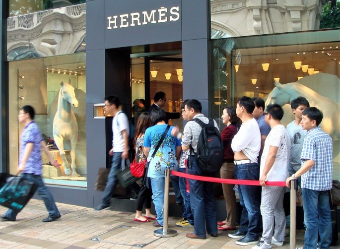 Chinese tourists line up outside an overseas Hermes store.