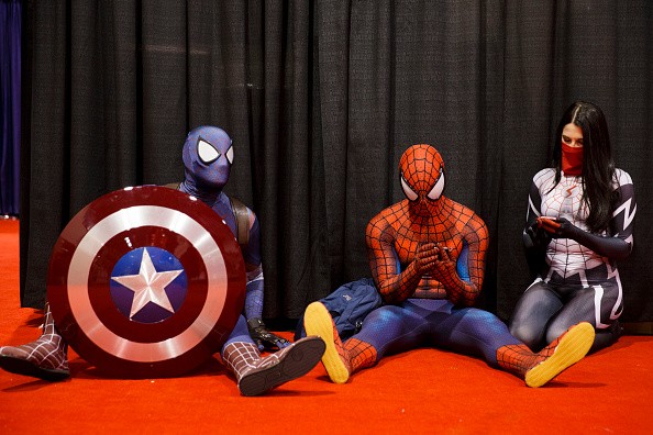 Attendees dressed as Marvel's Captain Spidey, left, Spiderman, center, and Silk take a break during the D23 Expo 2015 in Anaheim, California, U.S., on Friday, Aug. 14, 2015.