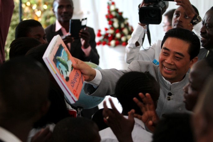 Lu Junqing, chairman of the China-Africa Project Hope, hands books to Hope School students in Nairobi, Kenya, Sept. 30, 2015.