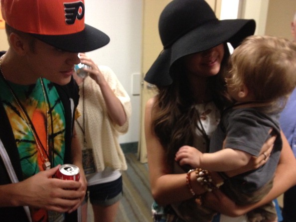 Justin Bieber and Selena Gomez relax backstage at a Phish concert on August 15, 2012 in Long Beach, California.