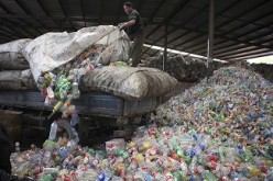 A worker unloads plastic bottles for recycling in Beijing.