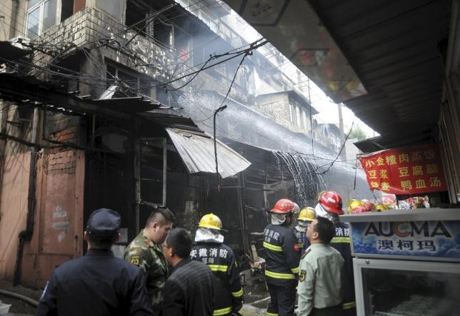 Firefighters try to extinguish a fire after an explosion at a restaurant in Wuhu, Anhui Province, China, Oct. 10, 2015.