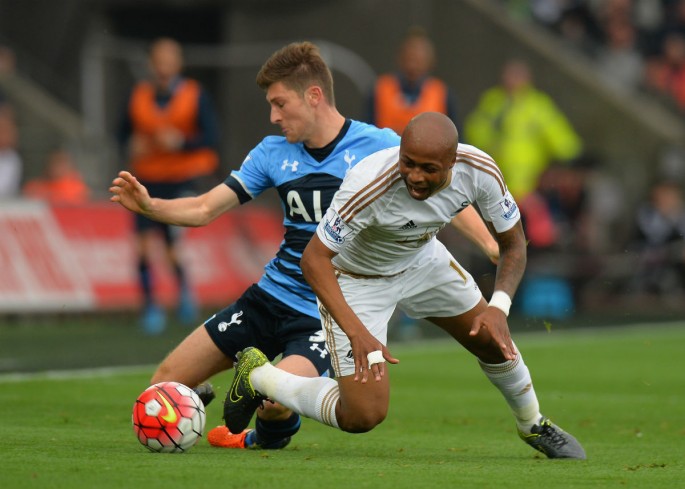Andre Ayew of Swansea City was tackled by Ben Davies of Tottenham Hotspur.