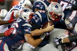 New England Patriots quarterback Tom Brady (#12) carries the ball for a first down during the 2014 AFC Championship game.