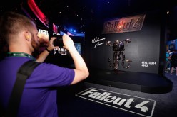 A game enthusiast takes a photograph of a 'Mr. Handy' robot in promotion to 'Fallout 4' at the Annual Gaming Industry Conference E3 at the LA Convention Center.