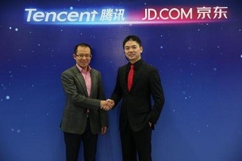Martin Lau, president of Tencent, and Richard Liu of JD.com shake hands during the announcement of their strategic partnership in e-commerce in March.