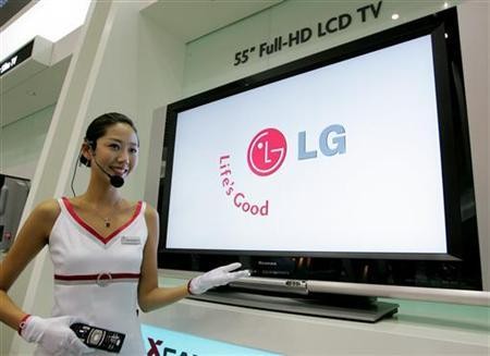 A saleswoman demonstrates the use of an LG Electronics 55-inch Full-HD LCD TV equipped with a liquid crystal display from LG.