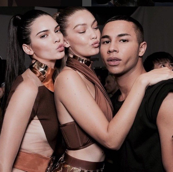Models Kendall Jenner and Gigi Hadid pose for a snap with Balmain's creative director Olivier Rousteing.