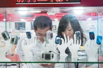 Visitors look at the smart bands and wearable devices displayed at an information technology expo in Shenzhen.